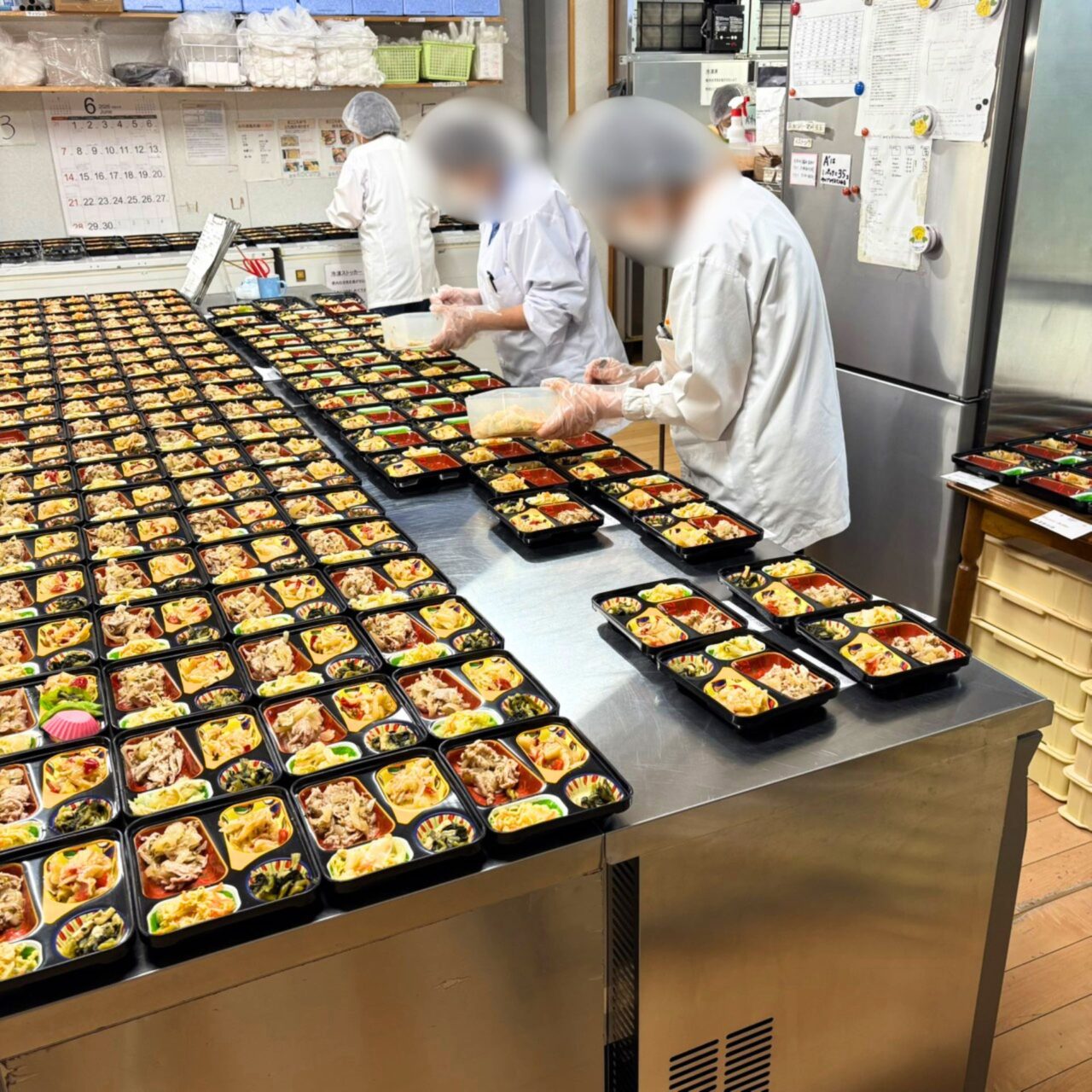 たくさんのお弁当を手作業で詰めている様子